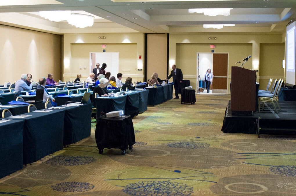 Attendees begin to fill the conference room